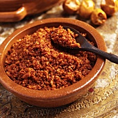 Achar masala in a terracotta bowl with a spoon