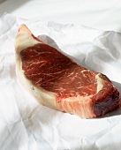 Raw beef steak on paper