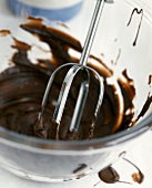 Beater of a mixer in melted chocolate