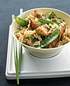 Brown Rice with Chicken, Snow Peas and Scallions on a Tray with Chopsticks