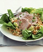 Sliced Pork on a Bed of Greens with Couscous, Raisins and Pine Nuts