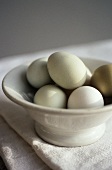 Fresh eggs in white bowl