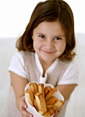 Girl holding bag of pieces of deep-fried cake