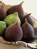 Green and purple figs in silver bowl