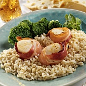 Scallops wrapped in bacon on rice