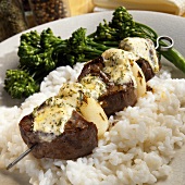 Beef kebab with onions and herb butter on rice