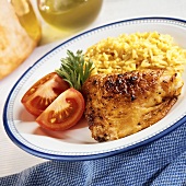 A Rotisserie Chicken Thigh with Yellow Rice and Tomatoes