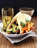 A Soft Shell Taco with Black Beans, Corn and Avocado Slices