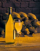 A Glass and Bottle of White Wine with Cobweb Covered Bottles