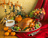 A Thanksgiving Roast Turkey with Gravy, Fresh Fruit and Pumpkins