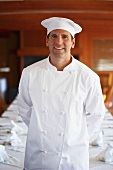 Chef in front of a laid table in a restaurant