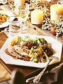 Holiday Table Setting with Roasted Turkey Slices with Gravy and Assorted Side Dishes on a Plate