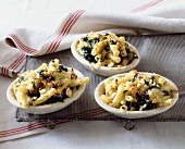 Macaroni and cheese with spinach on three plates