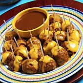 Platter of Enchilada Meatballs with Toothpicks Topped With Mexican Cheese Blend, Sauce
