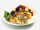 Serving of Vegetable Frittata with Fruit Salad on a White Plate, White Background