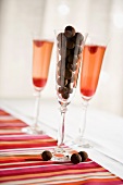 Chocolate truffles in glass, two glasses of raspberry champagne