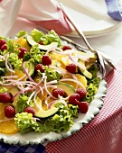 Plate of Salad with Oranges, Raspberries, Avocado and Red Onion; Spoons