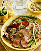 Sliced Grilled Beef with Grilled Vegetables on a Yellow Plate