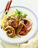Grilled Sausage with Polenta and Red Onion on a Plate; Knife and Fork
