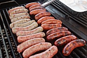 Pork and beef sausages on a grill rack