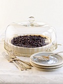 Blueberry pie under glass cover, cake plates and forks