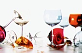 Empty coloured wine glasses, some broken