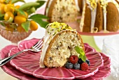Slice of Pistachio Citrus Cake on a Plate with Fresh Berries and a Fork