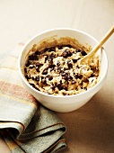 Wooden Spoon Mixing Chocolate Chips into Chocolate Chip Cookie Dough in a Mixing Bowl