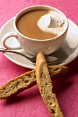 Zwei Biscotti und Tasse Kaffee mit Sahne