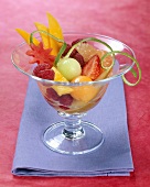 Fruchtsalat mit Limettenzeste in Glasschale
