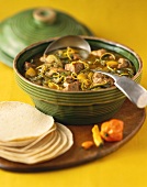 Schweinefleischeintopf mit grünen Chilischoten und Tortillas