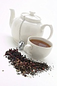 Tasse & Kanne aromatisierter schwarzer Tee, davor Teemischung