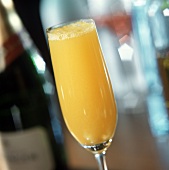 Champagne and orange in glass beside bottle