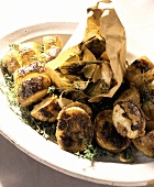 Baked potatoes and baked artichokes with herbs