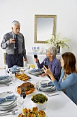 Man and Women Toasting with Red Wine Over Hanukkah Dinner Table