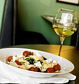 Bowl of Pasta with Tomatoes, Goat Cheese and Arugula, Glass of White Wine