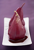 Two Poached Pears Sprinkled with Gold Dust on a Rectangular Dish