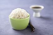 White Rice in a Small Green Bowl, Chopsticks, Sauce