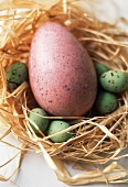 One Large Pink Easter Egg with Small Green Chocolate Eggs