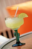 Margarita in kaktusförmigem Glas auf Tisch im Freien