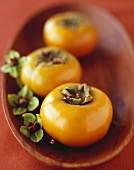A Row of Persimmons in a Shallow Wooden Bowl