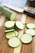 Partially Sliced Organic Zucchini on a Cutting Board