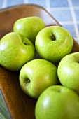 Many Organic Granny Smith Apples on a Wooden Dish