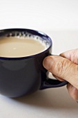 Hand Grabbing a Cup of Coffee by the Handle