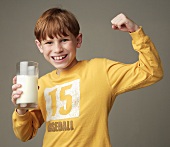 Little Boy Holding a Glass of Milk and Making a Muscle