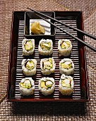 Sushi Rolls with Wasabi and Chopsticks on a Bamboo Tray