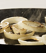 Onion rings being fried in a pan (close up)
