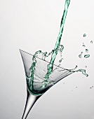 Grüner Martini wird in Glas gegossen