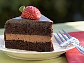 Slice of Layered Chocolate Cake Topped with a Strawberry