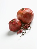 Two Pomegranates with Pepper Berries on White